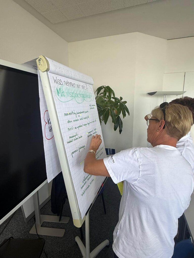 Munkatárs jegyzeteli a tanulmányút tanulságait egy flipchart táblán