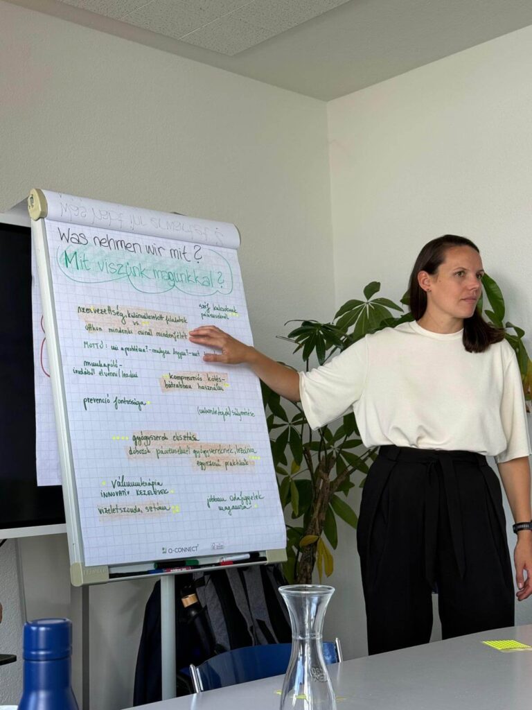 Munkatárs a flipchart táblán összegzett tapasztalatokat mutatja be